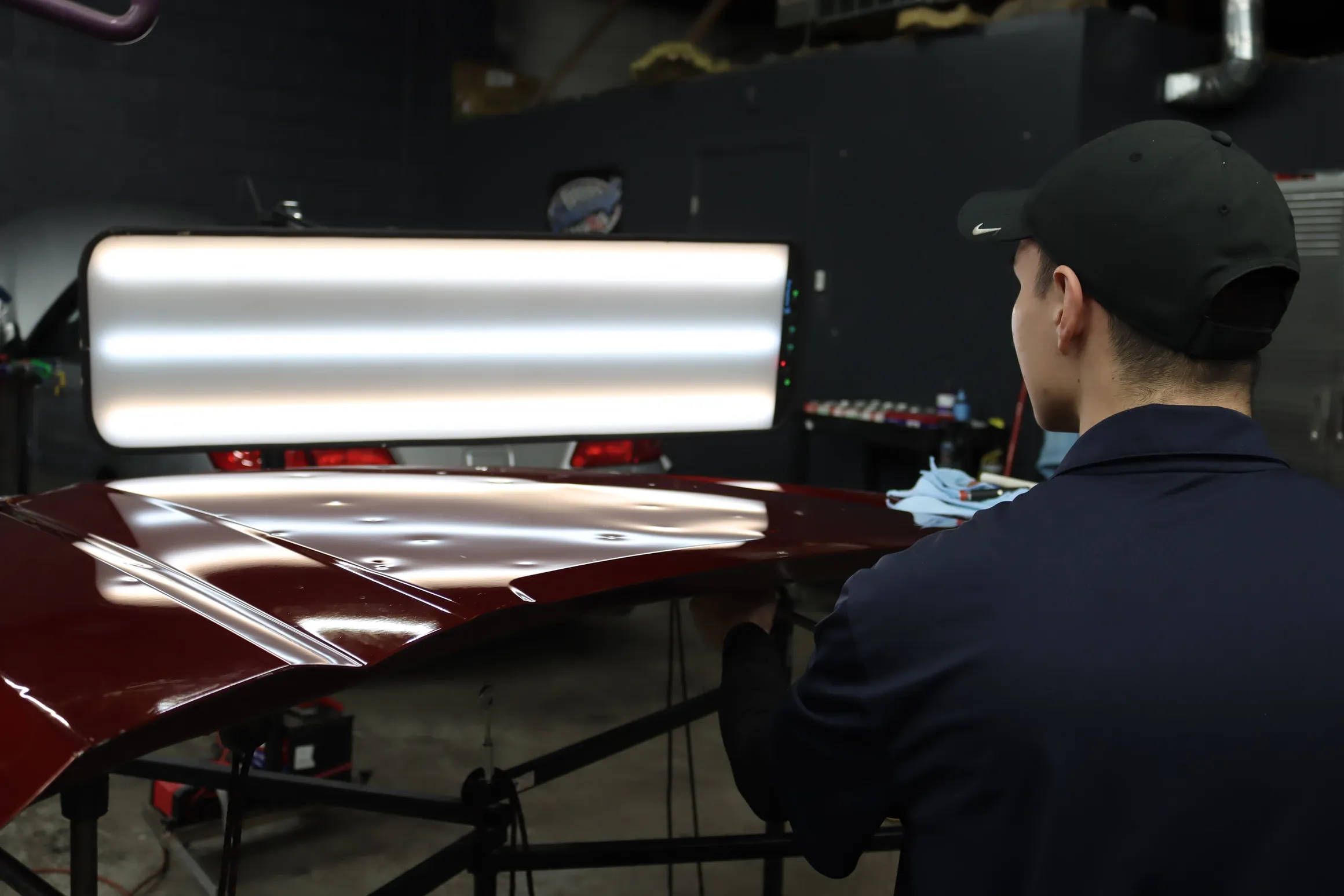 PDR Brothers technician inspecting hail dents under a paintless dent repair light