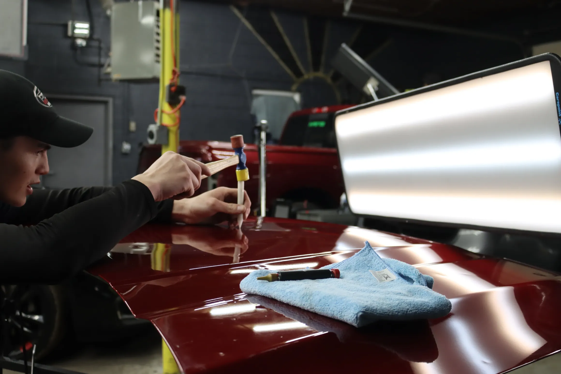 Paintless dent repair tools beside a vehicle panel
