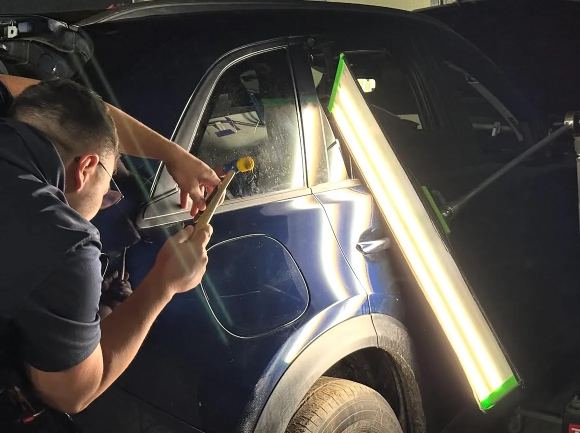 Paintless dent repair being performed on a vehicle roof
