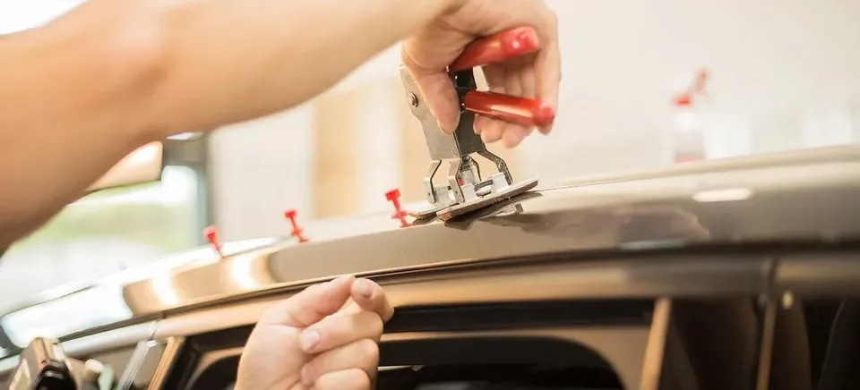 Paintless dent repair tools being used on a vehicle door